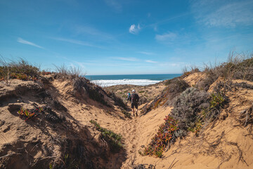 Vagabonds walk with sand dunes in the region in the Odemira region, western Portugal. Wandering along the Fisherman Trail, Rota Vicentina