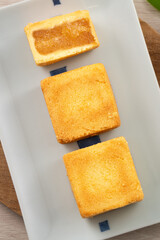 Delicious pineapple cake pastry in a plate on wooden table background with tea.