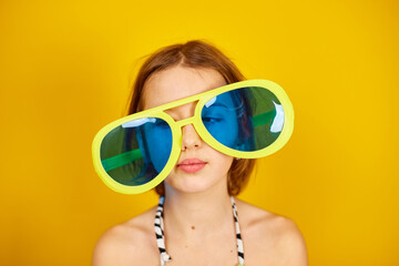 Smilling Child teenager girl in swimsuit and big sunglasses posing