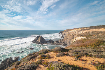 Typical scenery on the Atlantic coast. High rocky cliffs with sandy beaches in Odemira region, western Portugal. Wandering along the Fisherman Trail, Rota Vicentina
