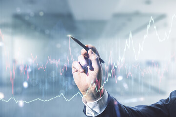 Man hand with pen working with abstract virtual financial graph on blurred office background, forex and investment concept. Multiexposure