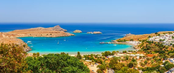 Papier Peint photo Europe méditerranéenne Sea skyview landscape photo Lindos bay and castle on Rhodes island, Dodecanese, Greece. Panorama with ancient castle and clear blue water. Famous tourist destination in South Europe