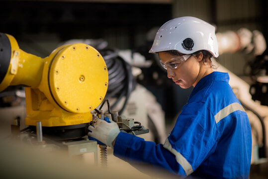 Caucasian female engineer, technician wearing safety uniform working use tablet Online information to monitor machine operation, check  maintenance plan to make a machine work efficiently and safely.
