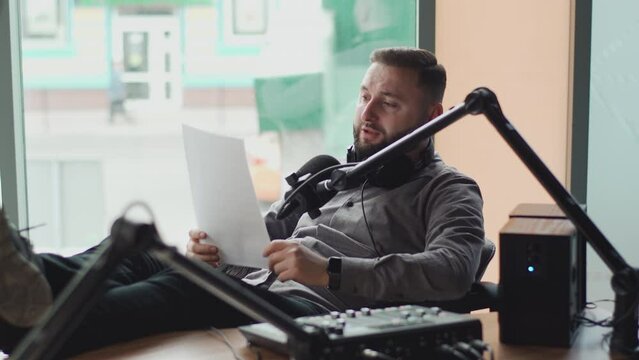 A handsome radio host speaks into a microphone during a radio broadcast.