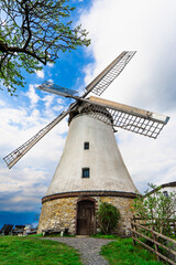 Historische Holländer Windmühle Lechtingen, bei leicht bewölktem blauen Himmel, vertikal 