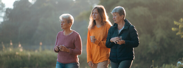 family of senior woman and teenager talking about activity recreation and picnic while coffee breakfast together in morning weekend, camping travel vacations trip in holiday, outdoor leisure party