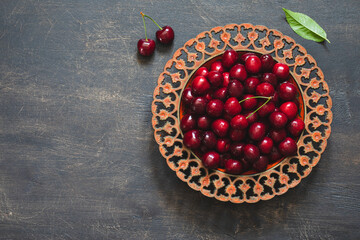 Composition of sweet cherries on a plate with water drops. Summer and harvest concept. Cherry macro. Vegan, vegetarian, raw food