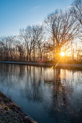 Beautiful sunset over a river with green bushes and color rich sky. High quality photo