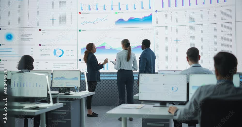 Poster Diverse Team Of Data Scientists Analyzing Information And Graphs On Big Digital Screen In Modern Monitoring Office. Multiethnic Employees Working Infront Of Desktop Computers In Consulting Firm.