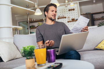 Man paying bills at home on his laptop.