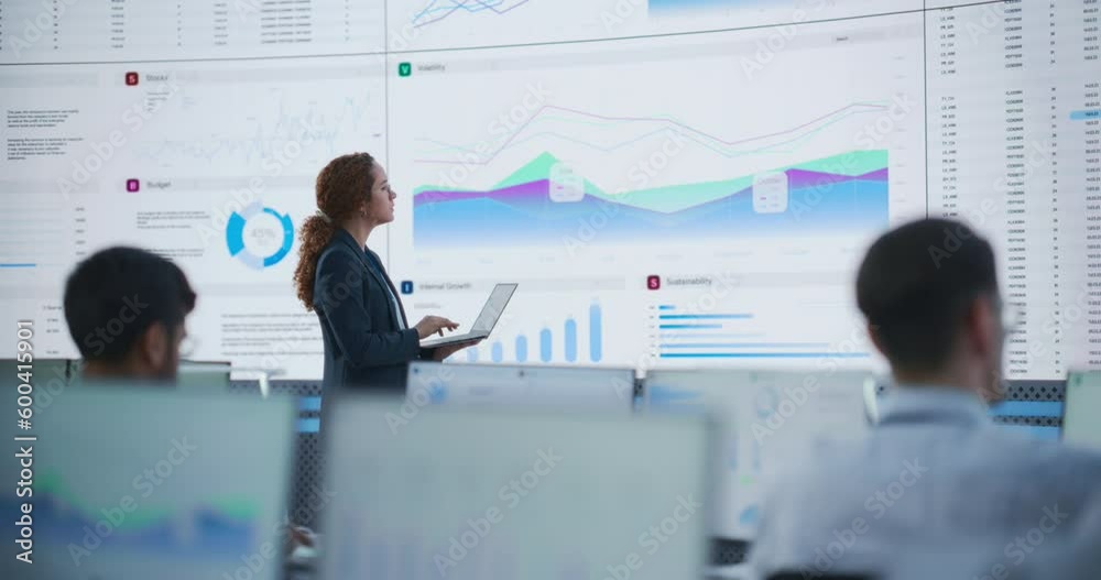 Poster Female Data Scientist Using Laptop And Analyzing Information Graphs On Big Digital Screen In Monitoring Office. Hispanic Woman Working For Big Data Company, Diverse Employees Behind Desktop Computers