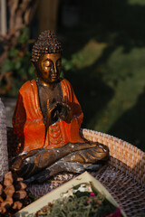 Statuette of Buddha in a lotus in the warm rays of the sun. A stylish concept of harmony and...