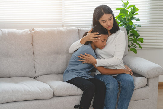 Mother And Child Relation Concept, Anxiety Young Girl To Be Comforted By Her Parent Hug At Home.