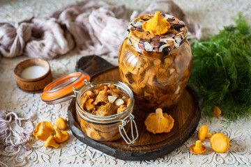 Preparation for winter: pickled chanterelles in a jar on a white background. A savory snack for...