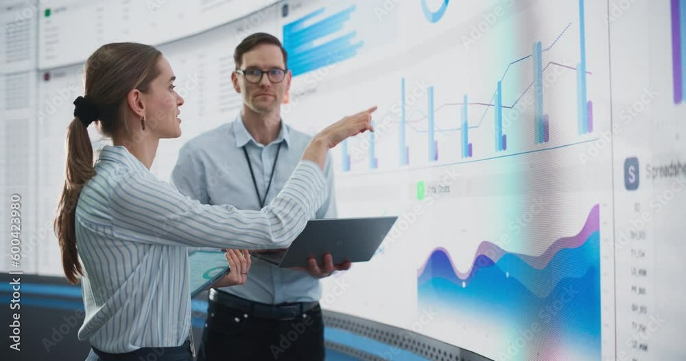 Aufkleber caucasian male and female data scientists with laptop and tablet standing next to big digital screen