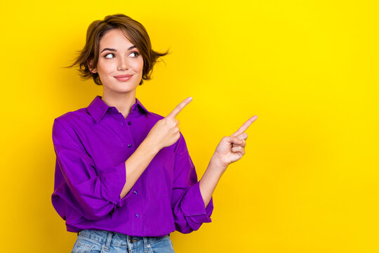 Photo of young consultant woman wear violet shirt direct fingers empty space tips for your business isolated on yellow color background