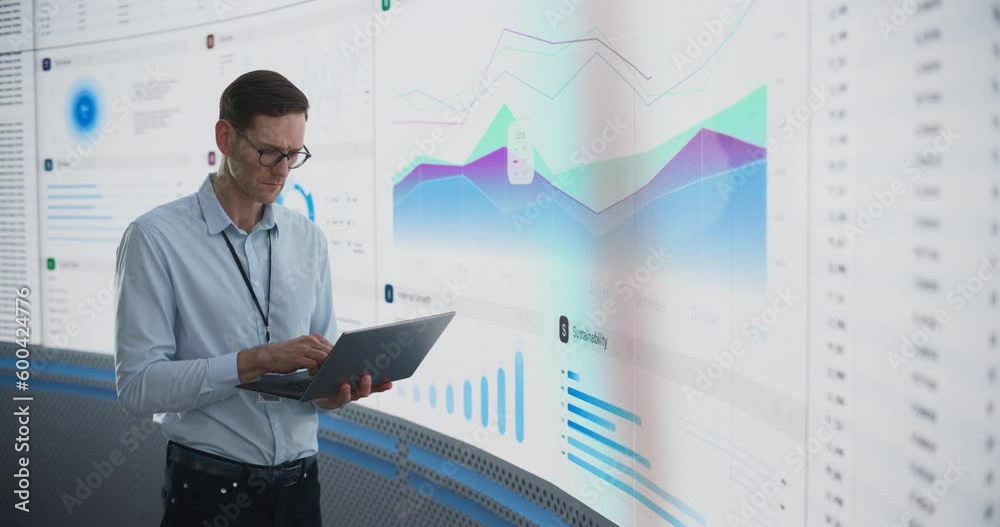 Aufkleber caucasian male business analyst holding laptop computer and standing next to big digital screen with