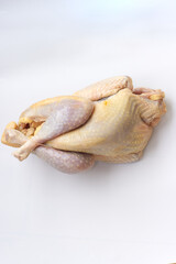 Close up on raw farm guinea fowl ready to cook on white background.