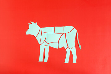 The scheme of cutting beef carcass from cardboard on a red background copy space