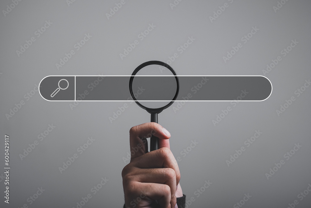 Wall mural hand holding magnifying glass. searching for information. using search console with your website. da