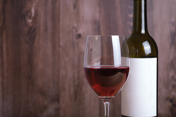 Close up red wine with the glass against wooden background. Celebration party restaurant menu with copy space for text.