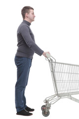 in full growth. casual young man with shopping cart.