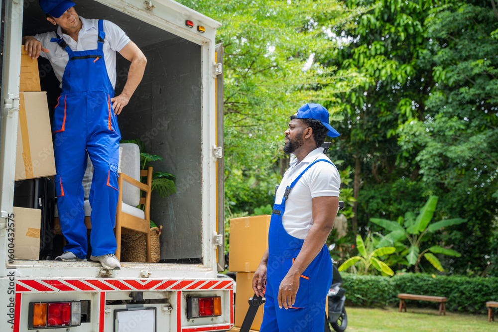 Poster removal company workers unloading boxes from truck into new home on moving day.