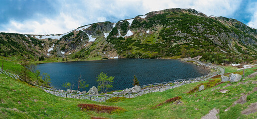 Fototapeta na wymiar Mały Staw - location at an altitude of 1,183 m above sea level (1183 AMSL). Visible slopes of Kocioł Mały Staw. Lake in the mountains. Giant Mountains National Park.