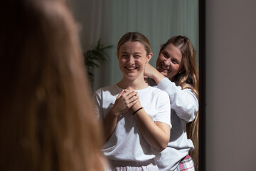 Happy young women looking in the mirror