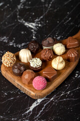 Praline Chocolate. Assorted truffles or praline chocolates on wood serving board