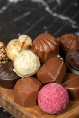 Praline Chocolate. Assorted truffles or praline chocolates on wood serving board. Close up