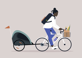 A young African parent riding a bike with a  kid trailer