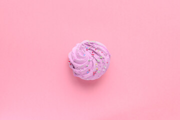 Single delicious purple meringues on pink background copy space