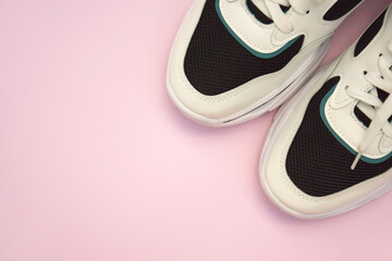 Bright female sneakers on light pink background. Fashion blog or magazine concept.
