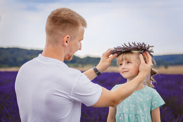 Father puts a lavender wreath on his daughter's head