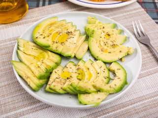 ripe avocado pulp cut into pieces sprinkled with lemon juice on a plate