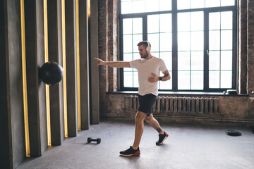 Fototapeta premium Man throwing medicine ball in modern gym