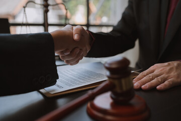 Businessmen shaking hands to sign agreement with lawyer or legal adviser and partner to discuss agreement and signing business venture agreement.