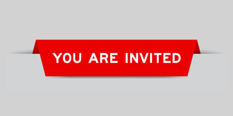 Red color inserted label with word you are invited on gray background