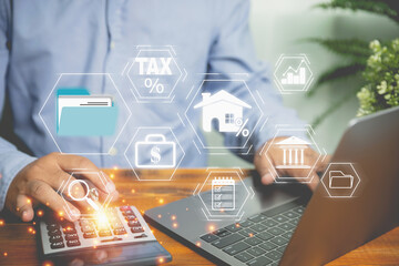 Businessman use a calculator calculate revenue for refund value tax. Using a laptop calculate cost...