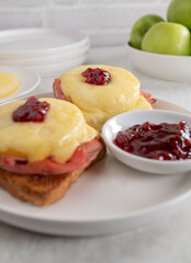 Toast hawaii with gratinated ham, pineapple, cheese and cranberry sauce