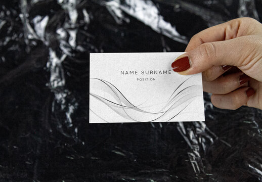 Business Card in Hand Mockup &ndash; Elegant Presentation on Glossy Black Wrinkled Plastic