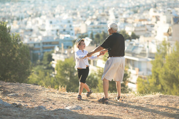 Old and Young. Family generation and relations concept. Retired grandfather and grandson playing with on sunny day, enjoying outdoor.