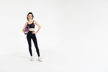 Fototapeta na wymiar Sports woman holding a fitness mat in her hands on a white background