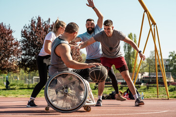 A physically challenged man in a wheelchair fearlessly engages in a spirited game of basketball with his supportive friends, breaking barriers and proving that passion and teamwork know no bounds.	 - 600459142