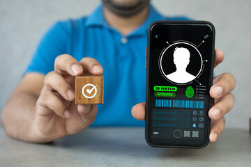 Man show digital ID card for match to database and holdig wood block of confirm for election vote....