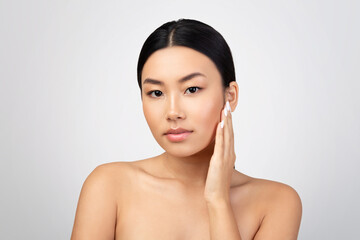 Asian Lady Touching Skin Enjoying Facial Skincare Result, Studio Shot