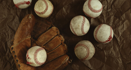 Vintage style baseball banner with used game balls on old glove background.