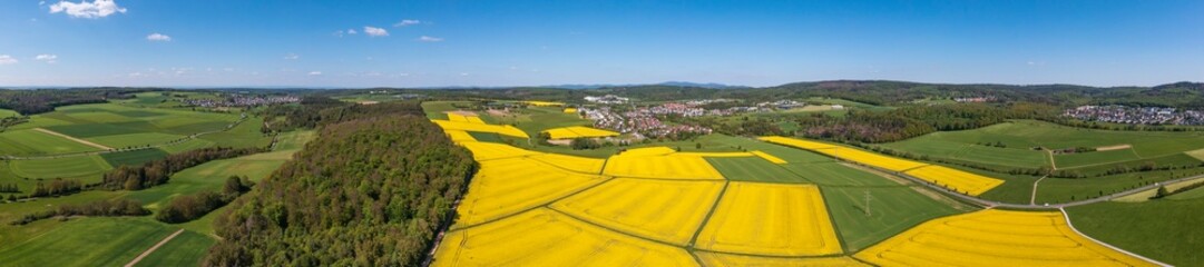 Panoramic aerial view of the Taunus landscape with flowering rapeseed fields near Taunusstein/Germany - obrazy, fototapety, plakaty