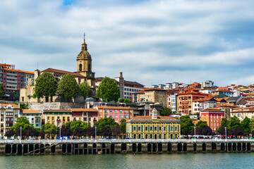 Fototapeta na wymiar View of Portugalete town by Nervion river, and Sandra Maria basilica, Basque Country, Spain.